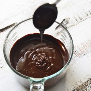 Spoon Dripping Hot Fudge Sauce Into Large Glass Measuring Cup